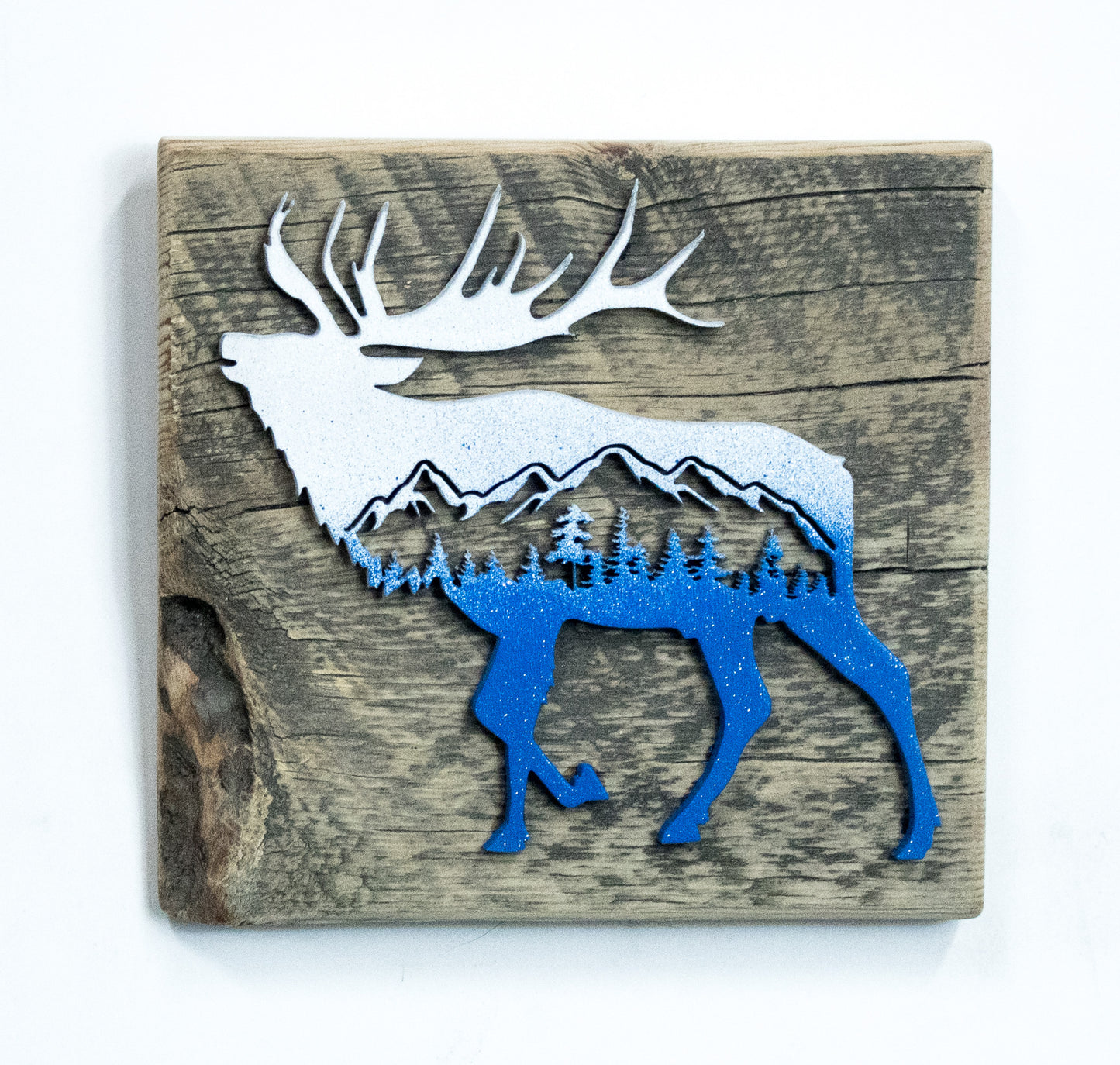 Decorative wall art with a blue and white deer silhouette on a wooden background